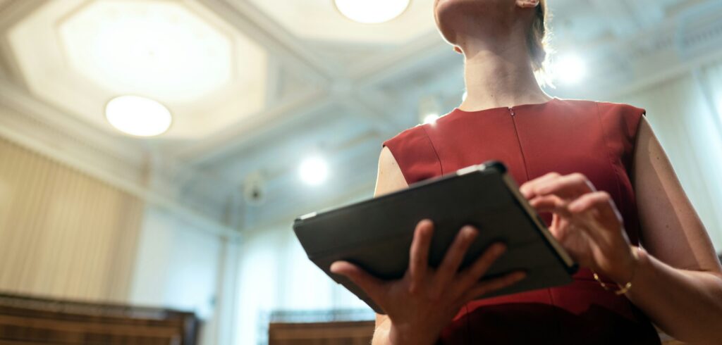 Woman in a government office holding a tablet.