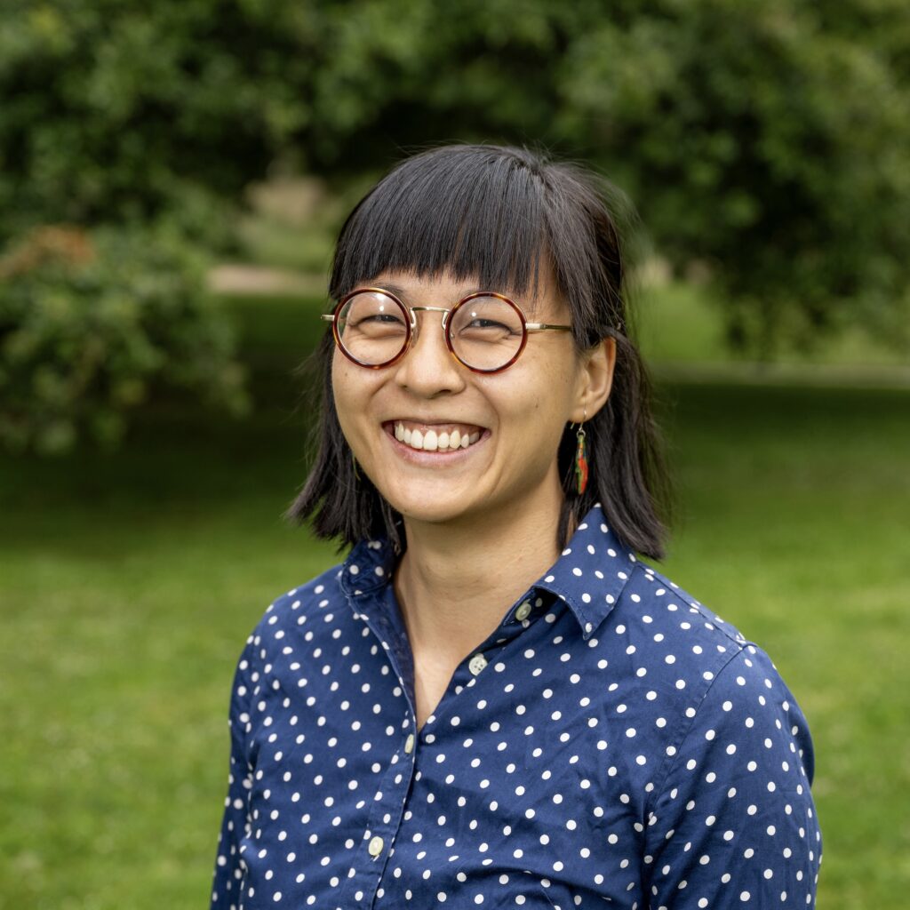 Alicia smiles at the camera in a polkadot, dark blue collared shirt.