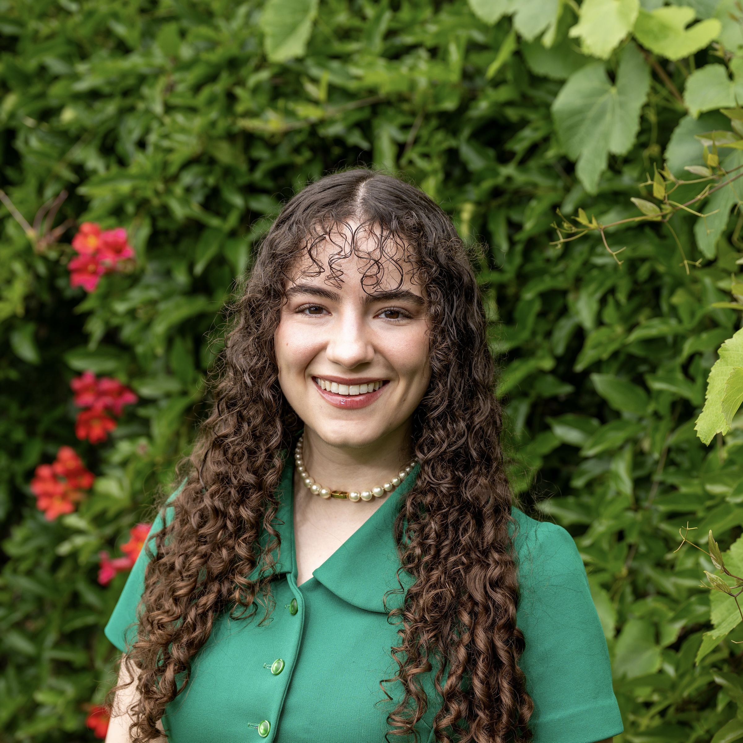 Alexandra smiles at the camera in a bright green dress.