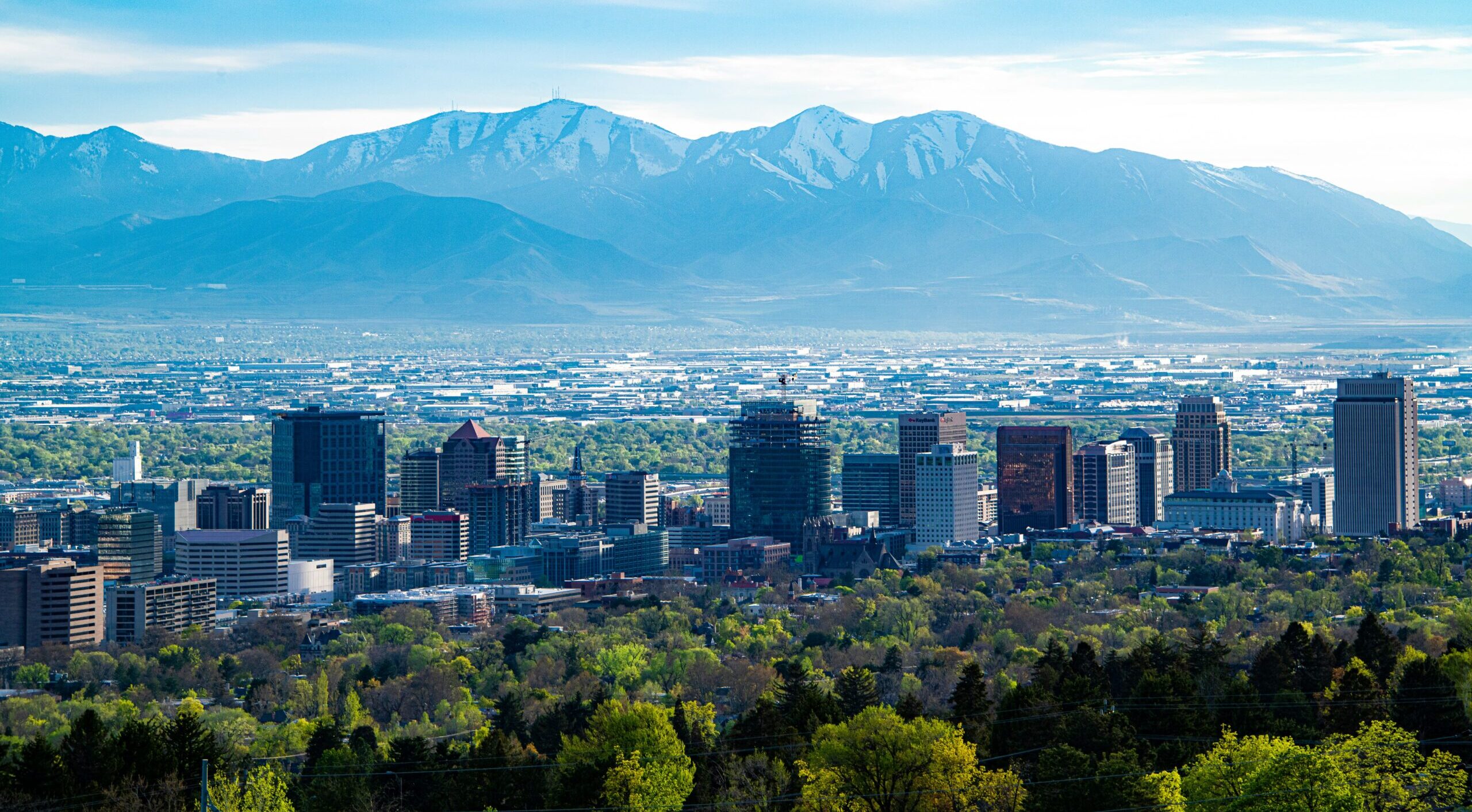 A city skyline across green mountain during daytime.