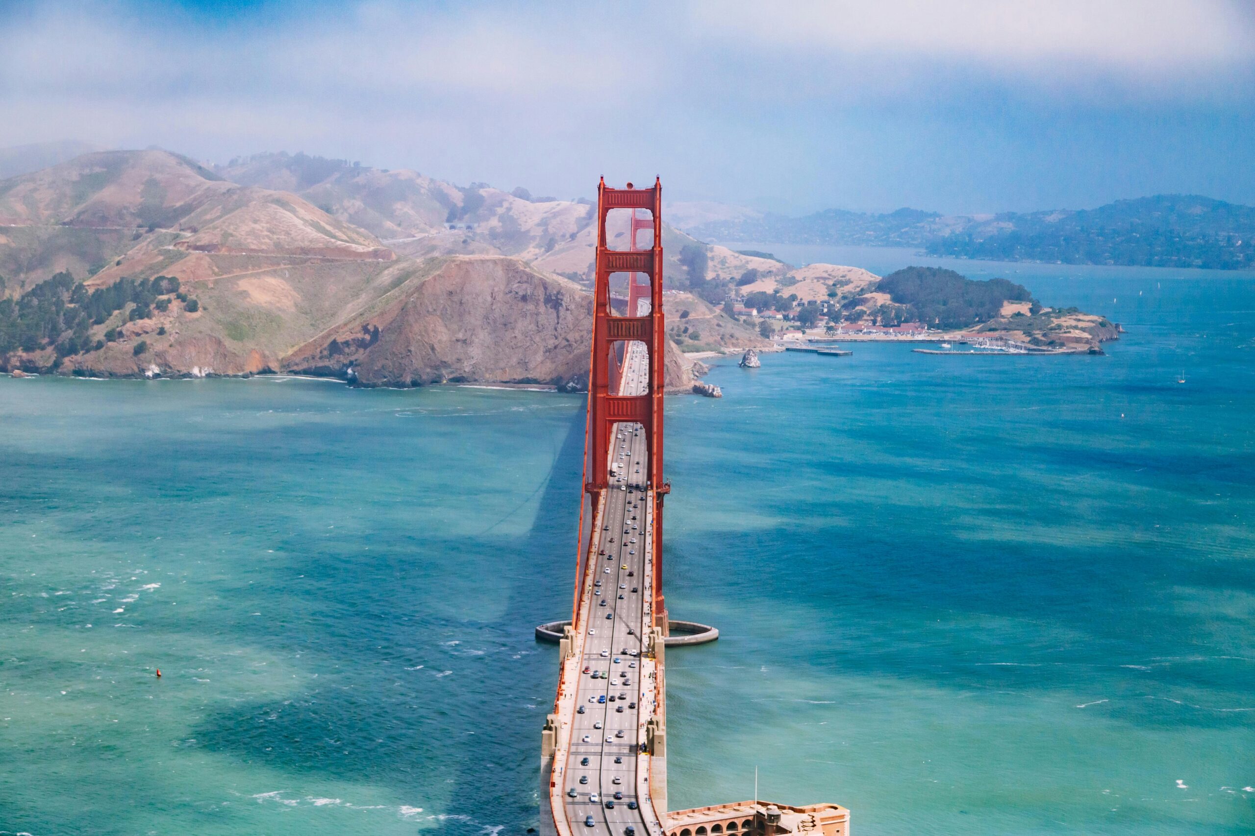 Cars cross the Golden Gate Bridge on a sunny day.