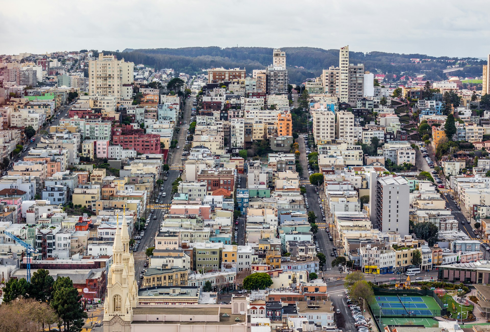A shot of a sloping hill covered in buildings and trees.