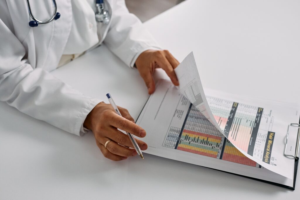 A doctor flips through medical records highlighted in red, yellow, and green.