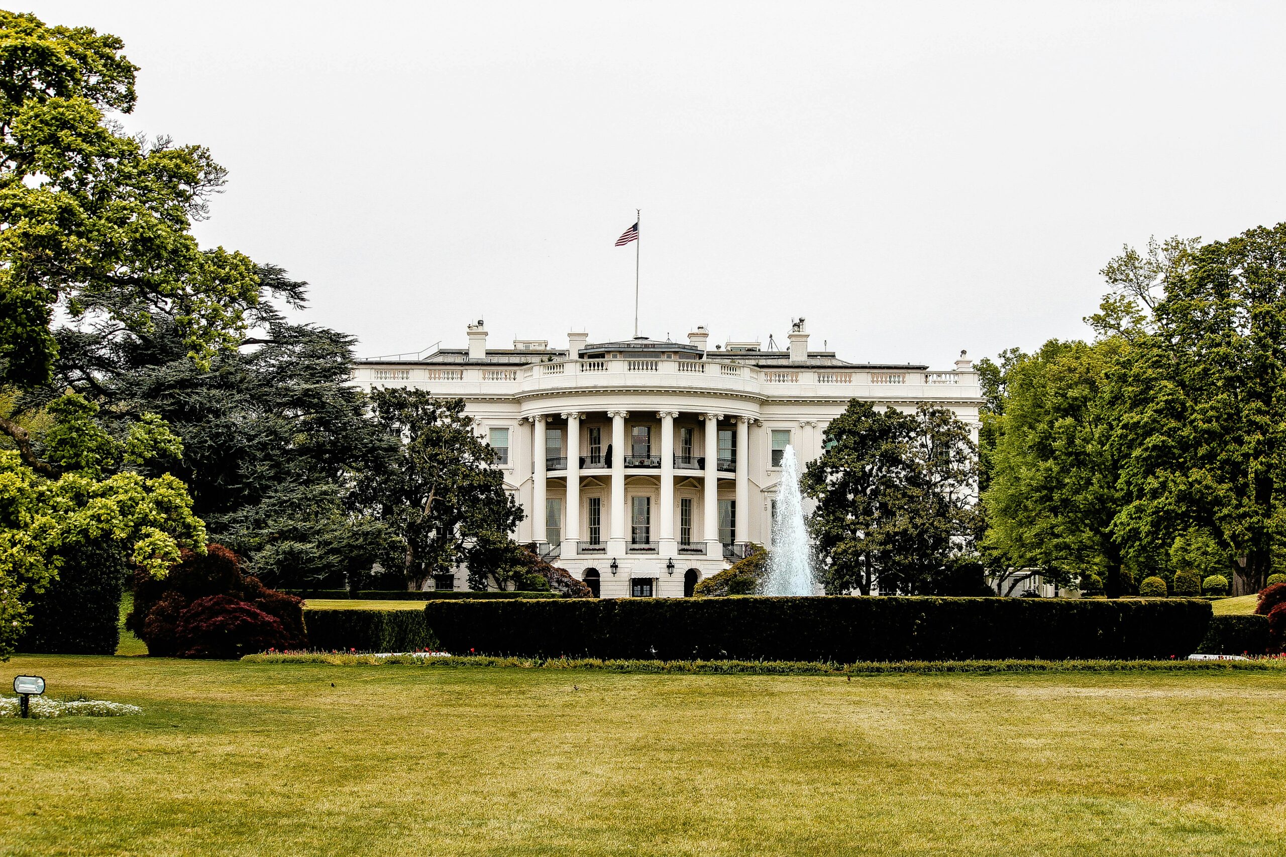 [Image] Front of the white house surrounded by greenery.